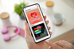 Female hands holding phone with app heart and activity