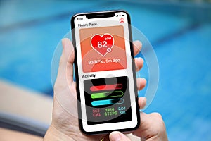 Female hands holding phone with app heart and activity screen