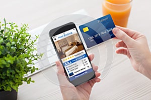Female hands holding phone app hotel booking and credit card