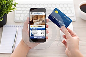 Female hands holding phone app hotel booking and credit card