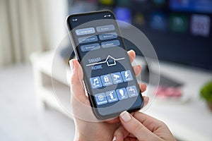 Female hands holding phone with app smart home on screen