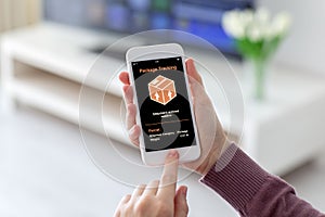 Female hands holding phone with app tracking delivery package sc