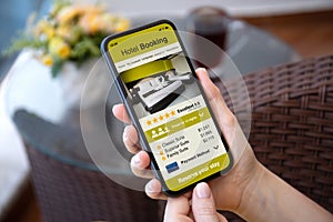 Female hands holding phone with application hotel booking on screen