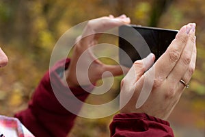 Female hands holding phone outdoor