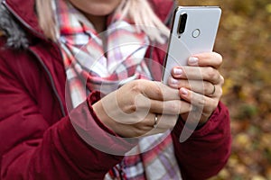 Female hands holding phone outdoor