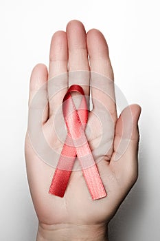 female hands holding red AIDS awareness ribbon