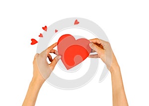 Female hands holding red Valentines card with heart on a white b