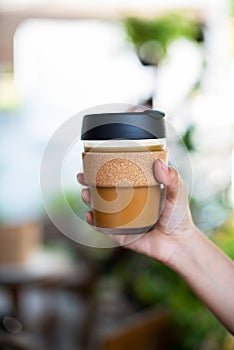 Female hands holding reusable coffee cup,