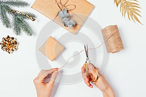 Female hands holding scissors cutting twine to make homemade wrapping
