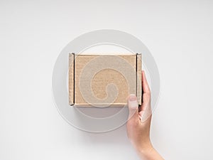 female hands holding a small cardboard box on a white background