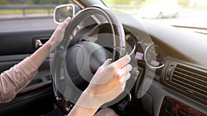 Female hands holding steering wheel, woman driving car, comfortable vehicle