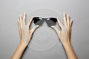 Female hands holding sunglasses. Woman with Glasses