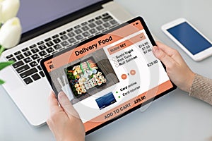 Female hands holding tablet with app delivery food on screen