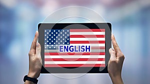 Female hands holding tablet with English word against USA flag, online app