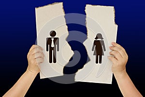 Female hands holding a torn poster separating the symbol of a man and a woman, the concept of a breakup, divorce, separation,