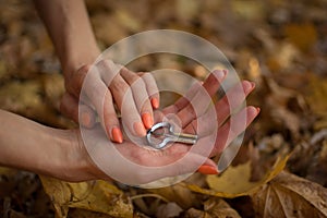 Female hands are holding traditional hutsul drymba or jew`s-harp, the oldest musician instrument in the world on fallen