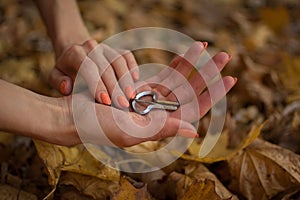 Female hands are holding traditional hutsul drymba or jew`s-harp, the oldest musician instrument in the world on fallen