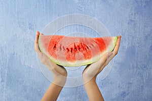 Female hands holding watermelon slice on light background