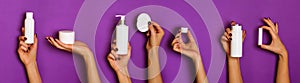 Female hands holding white cosmetics bottles - lotion, cream, serum on violet background. Banner. Skin care, pure beauty, body photo