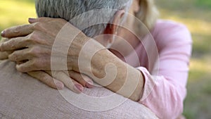 Female hands hugging husband neck, old couple kissing and embracing, mature love