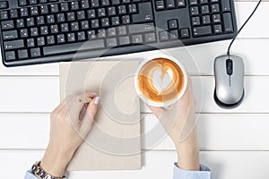 Female hands keyboard mouse from computer notebook pen cup of coffee