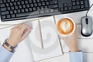 Female hands keyboard mouse from computer notebook pen cup of coffee