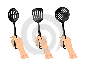 Female hands with kitchen utensils: slotted spoon, spatula photo