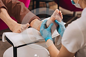 Female hands kneading male foot