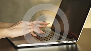 Female hands on laptop, close-up