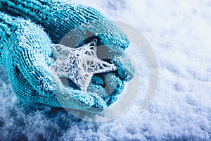 Una donna mani la luce lavorato maglia guanti intrecciate bianco stella sul bianco la neve. un 