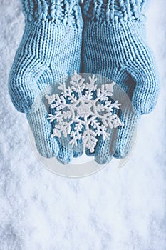 Una donna mani la luce lavorato a maglia guanti scintillante favoloso Fiocco di neve sul la neve. un 