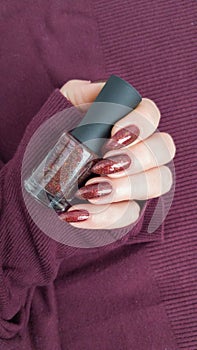 Female hands with long nails with brown nail polish