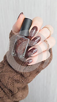 Female hands with long nails with brown nail polish