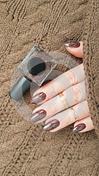 Female hands with long nails with brown nail polish