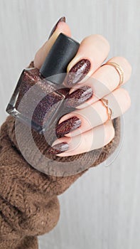 Female hands with long nails with brown nail polish