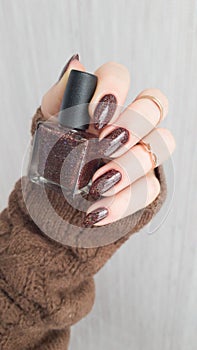 Female hands with long nails with brown nail polish