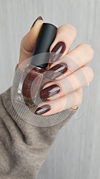 Female hands with long nails with brown nail polish