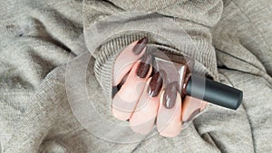 Female hands with long nails with brown nail polish