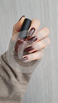 Female hands with long nails with brown nail polish