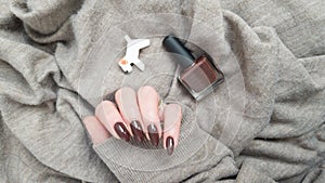 Female hands with long nails with brown nail polish