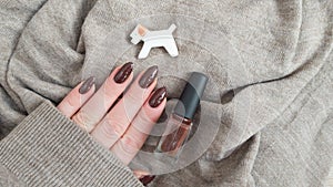 Female hands with long nails with brown nail polish