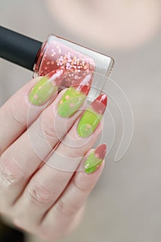 Female hands with long nails and green and brown thermo manicure