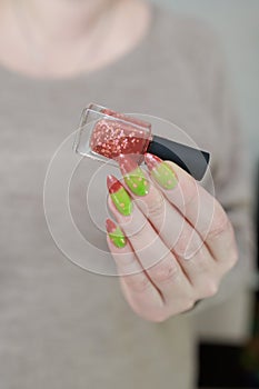 Female hands with long nails and green and brown thermo manicure