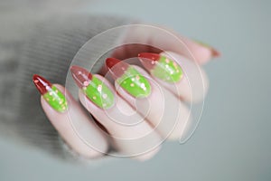 Female hands with long nails and green and brown thermo manicure