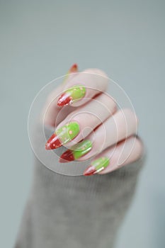 Female hands with long nails and green and brown thermo manicure