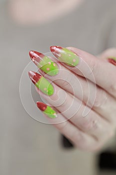 Female hands with long nails and green and brown thermo manicure