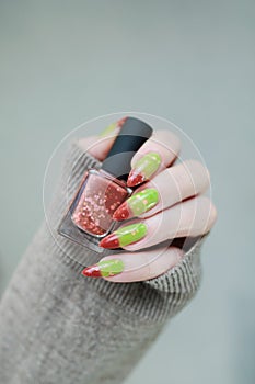 Female hands with long nails and green and brown thermo manicure