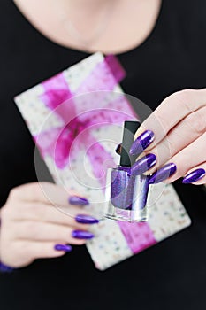 Female hands with long nails hold a gift box