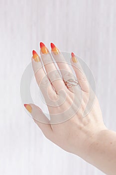 Female hands with long nails with yellow and red nail polish
