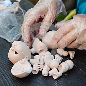 Female hands make dolls of BJD in the workplace. Processing the